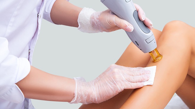 Close-up of a cosmetologist doing a laser hair removal procedure for leg